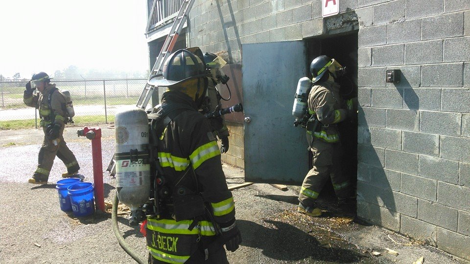 Firefighters in Gear Entering and Exiting a Building