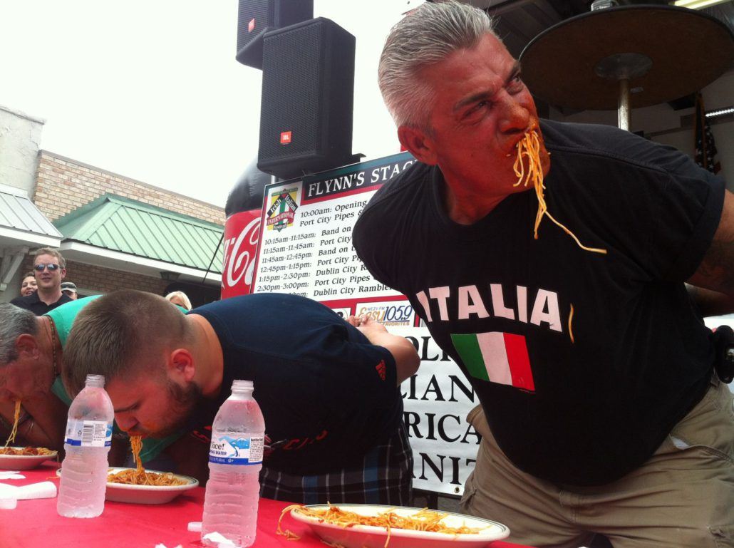 Participants with Their Hands Behind Their Back Eating Plates of Spaghetti