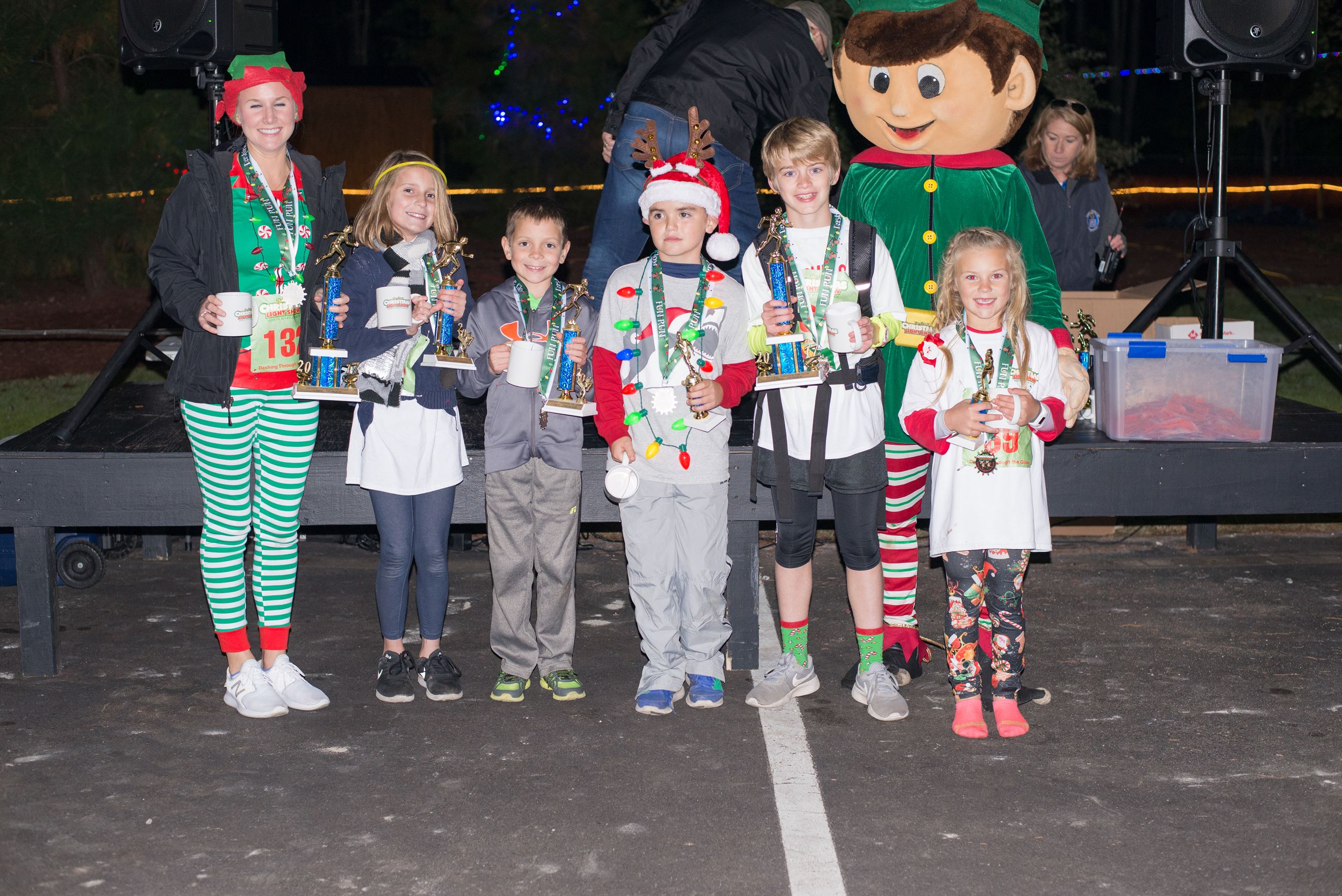 Kids Holding Trophies in Christmas Outfits