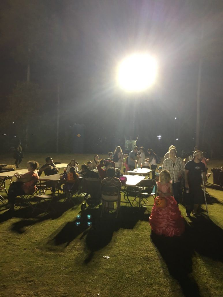 Howl-O-Scream participants sitting at picnic tables at night